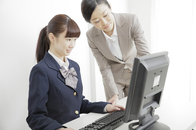 PC画面を使って説明するスタッフとそれを聞く学生